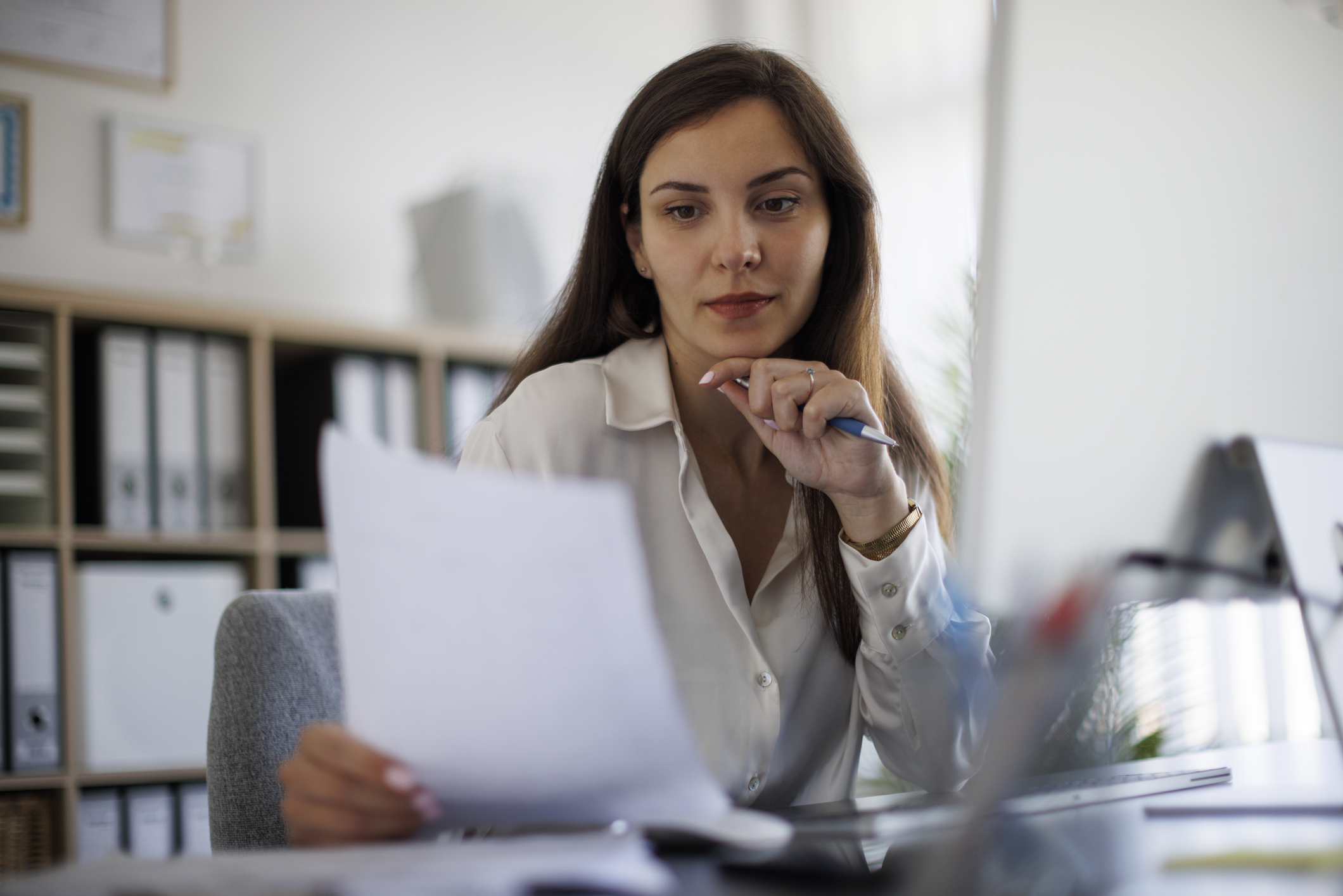 Young businesswoman reviewing documents at her desk